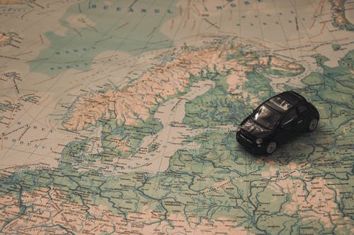 世界地图纸上的黑色玩具车 · 免费素材图片