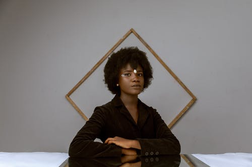 非洲黑人的头发，优雅的年轻黑人女性，休息在房间里附近装饰墙与框架 · 免费素材图片