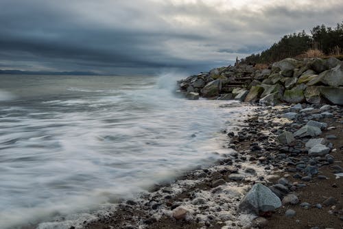 多云的天空下的岩石海岸 · 免费素材图片