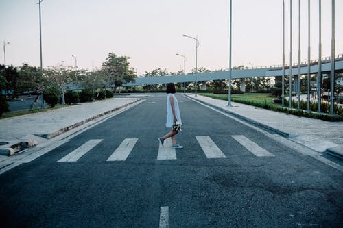 女人站在灰色和白色的道路人行横道 · 免费素材图片