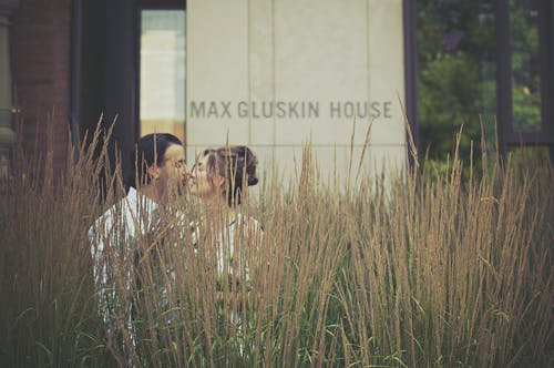 男人和女人在绿色的植物附近接吻 · 免费素材图片