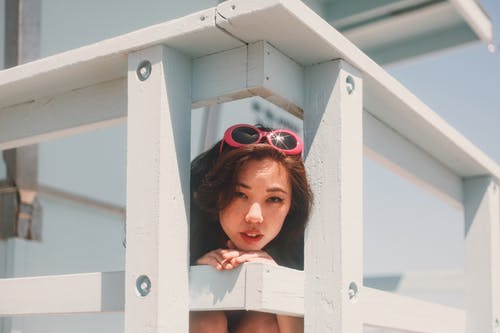 靠在木栅栏上的女人的照片 · 免费素材图片