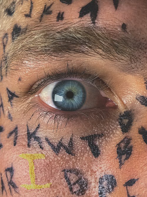 播种蓝眼睛的人脸上涂着字母 · 免费素材图片