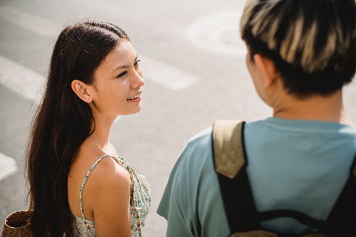 站立在与男朋友的行人穿越道的微笑的年轻女朋友 · 免费素材图片