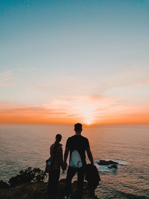 黄金时段夫妇站在海边 · 免费素材图片
