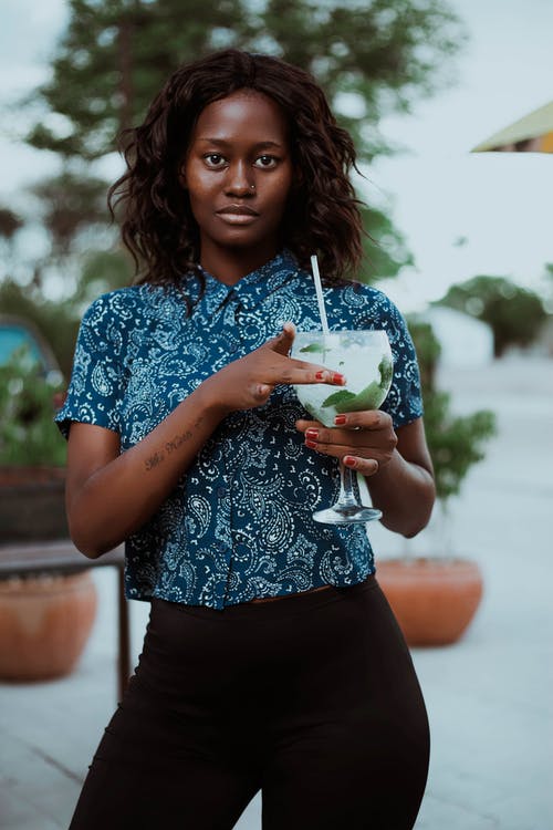 女人拿着酒杯的浅焦点照片 · 免费素材图片