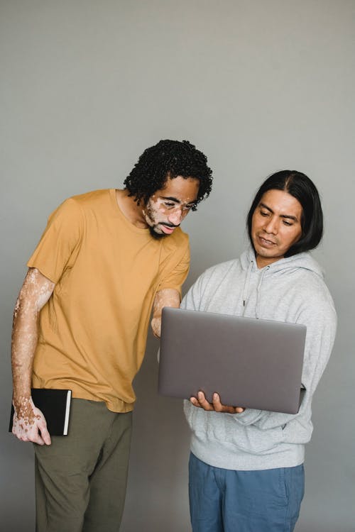 积极多种族的同事一起使用笔记本电脑 · 免费素材图片
