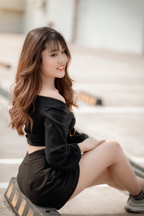 黑色的长袖上衣和黑色的短裙，坐在黑色的木凳上的女人 · 免费素材图片