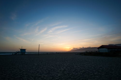 蓝蓝的天空，日出时的棕色云下的海滨 · 免费素材图片