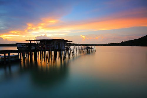 在日落的照片在水面上的木屋 · 免费素材图片