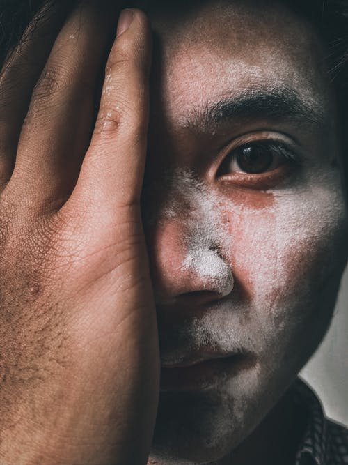 男子捂着脸的特写照片 · 免费素材图片