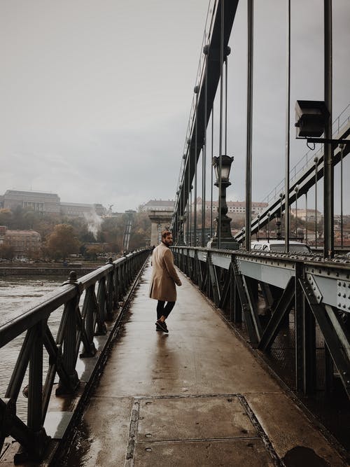 棕色外套和黑色的裤子，在桥上行走的人 · 免费素材图片