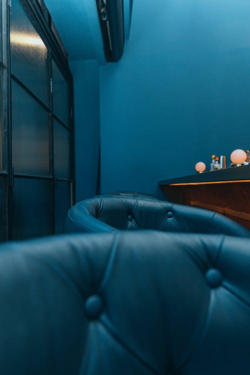 棕色木桌旁边的蓝色皮革沙发 · 免费素材图片