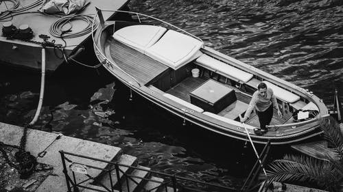 人在一条船在河上的灰度照片 · 免费素材图片