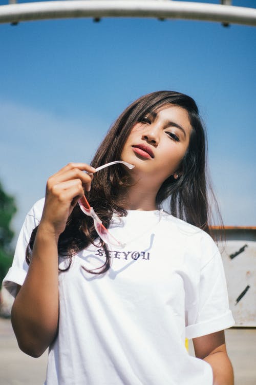 白乘员脖子t恤，拿着太阳镜的女人 · 免费素材图片