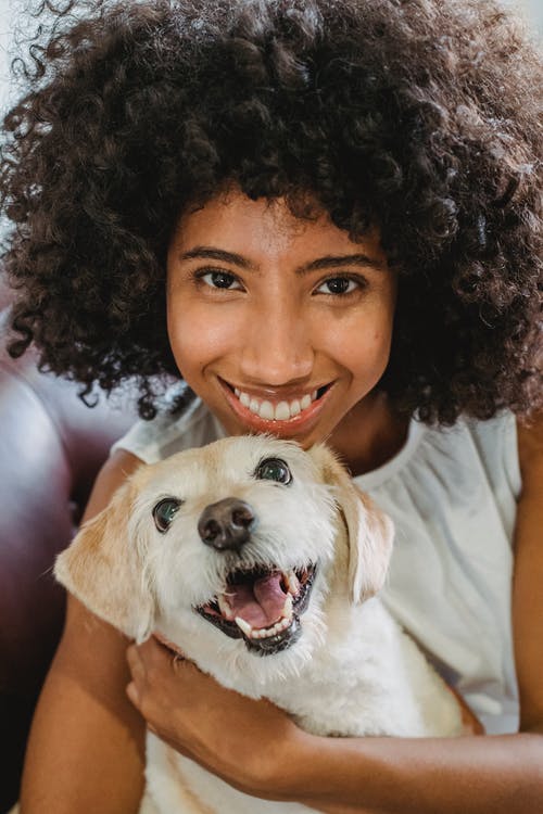幸福的黑女人拥抱有趣的狗 · 免费素材图片
