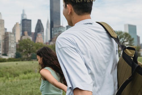 在城市播种微笑的夫妇手牵着手在草地上 · 免费素材图片