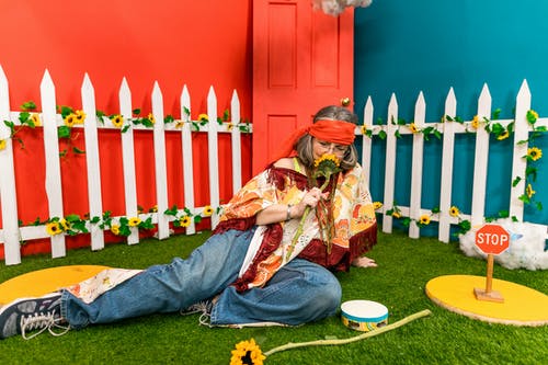 老妇坐在一朵花的草地上 · 免费素材图片