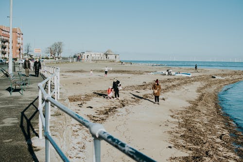 人们走在沙滩线附近 · 免费素材图片