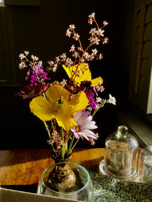 透明玻璃花瓶中的黄色和粉红色花朵 · 免费素材图片