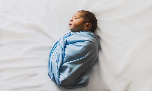用蓝色毯子盖着的新生婴儿的照片 · 免费素材图片