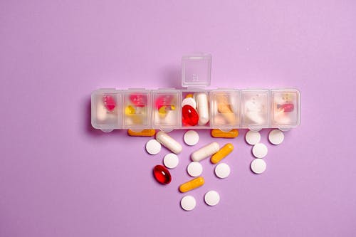 紫罗兰色表面上的透明塑料药品容器 · 免费素材图片