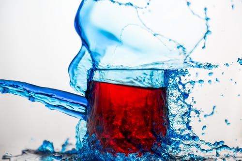 蓝色透明玻璃杯溅起的水 · 免费素材图片