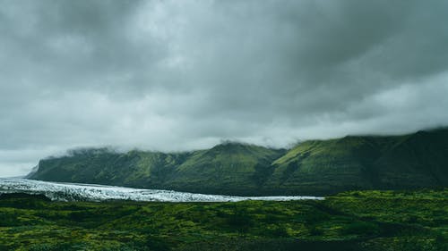 多云的天空下的绿山 · 免费素材图片