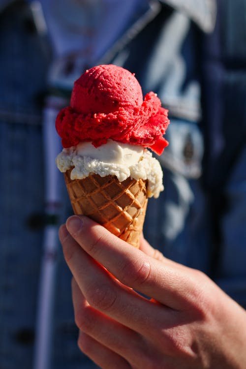 持有与草莓冰淇淋冰淇淋蛋筒的人 · 免费素材图片