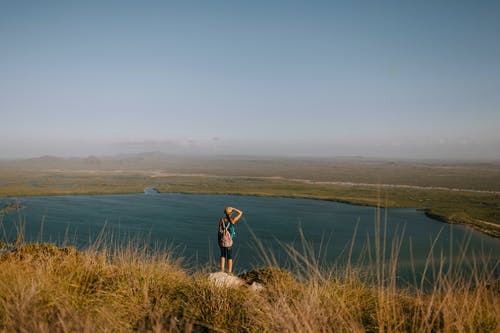 不露面的旅行者正在考虑湖山从朦胧的天空下 · 免费素材图片