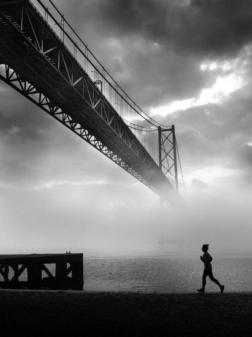 在河边慢跑的人的灰度照片 · 免费素材图片