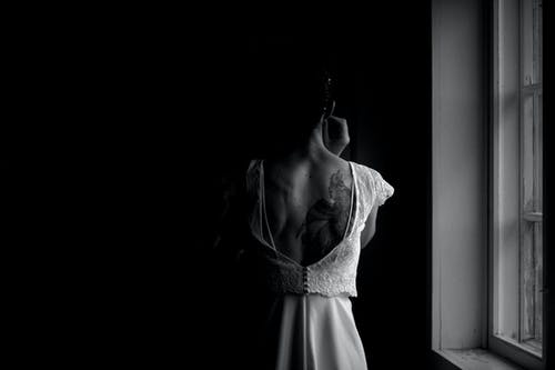 站在窗户旁边的人的灰度摄影 · 免费素材图片