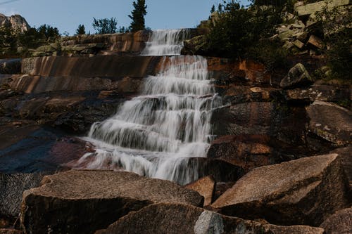 干净的瀑布在岩石地层上流动 · 免费素材图片