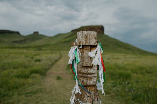 木制偶像与草地上的愿望丝带 · 免费素材图片