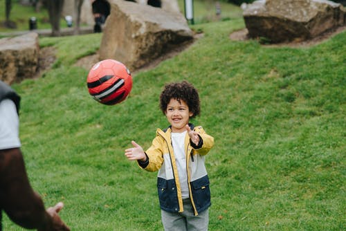 性格开朗的黑人男孩玩球 · 免费素材图片