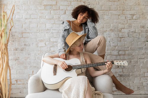 音乐家为黑人妇女弹吉他 · 免费素材图片