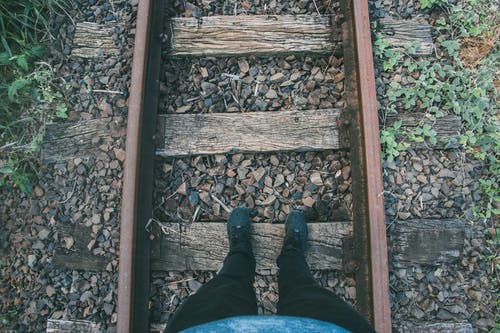 黑色的牛仔裤和运动鞋踩木步道的人 · 免费素材图片