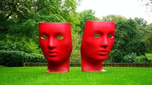 在绿草地上的红色人脸纪念碑 · 免费素材图片