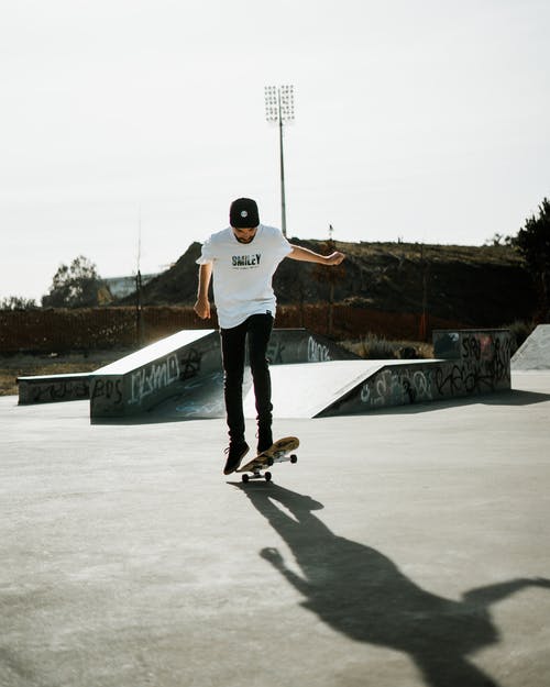 玩滑板的白衬衫和黑裤子的男人 · 免费素材图片