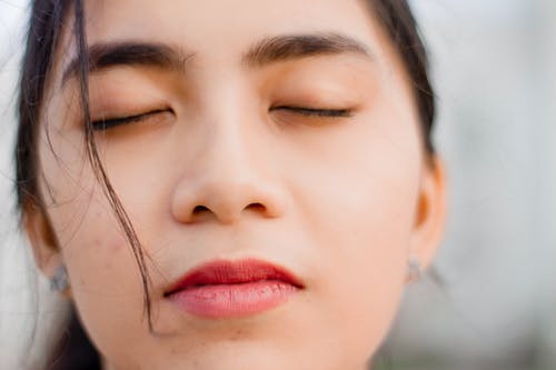 女人的脸，闭着眼睛的选择性焦点特写照片 · 免费素材图片