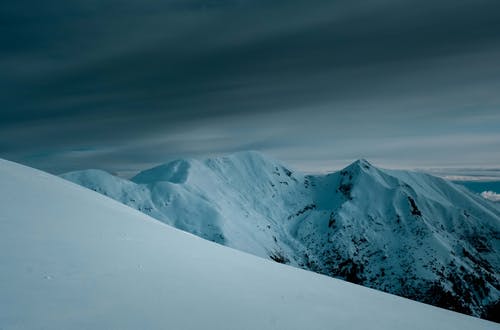 多云的天空下的积雪的山 · 免费素材图片