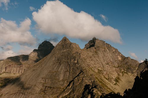 岩石的崎mountains山脉，在明亮的多云的蓝天下 · 免费素材图片