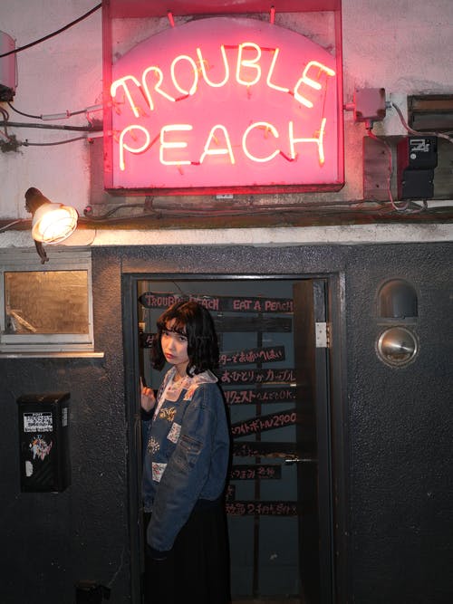 站在麻烦桃酒吧附近的女人 · 免费素材图片