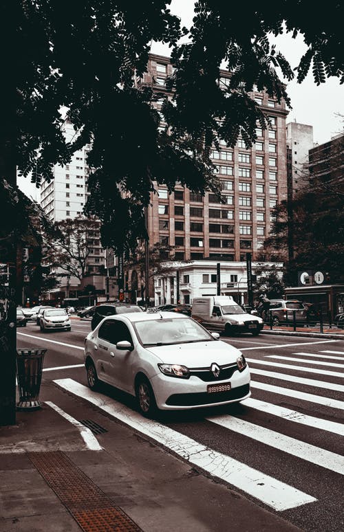 白色轿车在行人专用道上的照片 · 免费素材图片