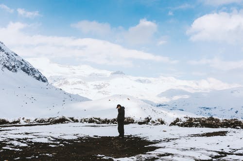 黑色衬衫站在白雪原上的男人 · 免费素材图片