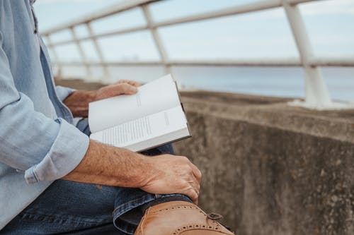 人在河海岸的阅读书 · 免费素材图片