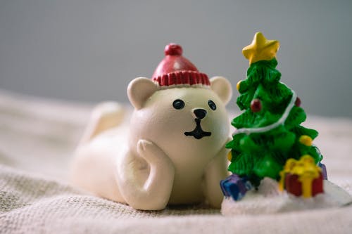 白色北极熊在圣诞树雕像旁边的特写照片 · 免费素材图片