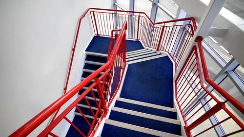 蓝色的楼梯和红色处理白漆墙上 · 免费素材图片