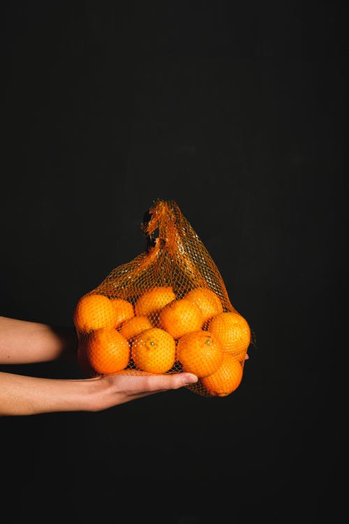 人控股束水果在黑色背景上 · 免费素材图片