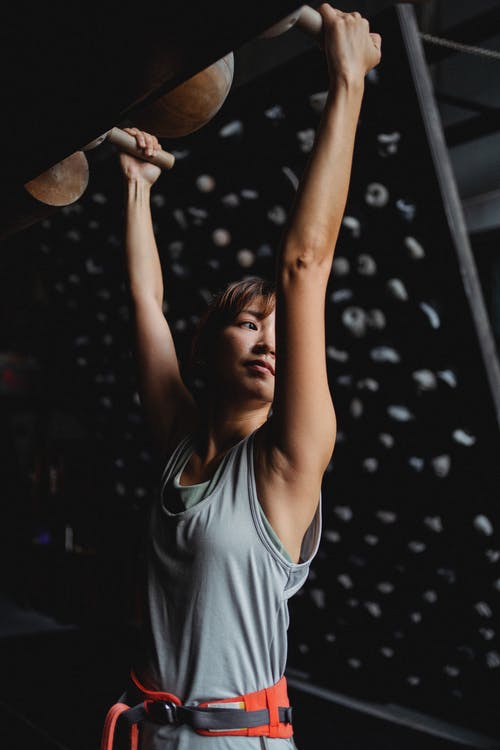 垂悬在体操设备上的正面亚裔妇女在上升的演播室 · 免费素材图片